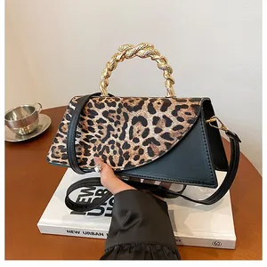 Detail of leopard print flap bag with gold twisted metal handle and black leather base