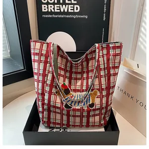 Close-up of red checkered canvas tote bag with cute dog embroidery in premium packaging