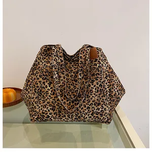 Close-up of leopard print tote bag with side pocket and metallic stud decoration