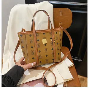Detail shot of brown shoulder bag with teddy pattern on a white blazer over a chair