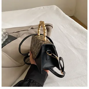 Detail of leopard print flap and unique golden twist metal handle on mini handbag
