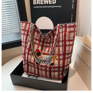 Detailed close-up of a red checkered canvas tote bag with a cute puppy towel embroidery