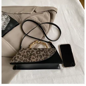 Top view of leopard print crossbody bag with gold twisted handle and fashion accessories