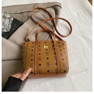 Detail view of brown bear pattern bucket bag with gold hardware and textured leather