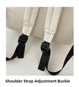 Close-up of adjustable shoulder strap buckle with black nylon webbing on beige backpack