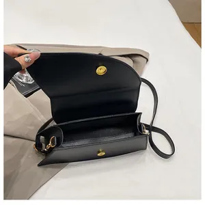 Close-up showing the interior space and golden magnetic closure of the black square bag