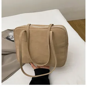 Detail of minimalist khaki frosted tote bag with silver zipper and slender straps