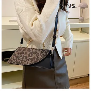 Detail of leopard print crossbody bag featuring a gold chain handle and black PU leather