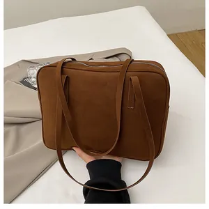 Macro detail of the dark brown matte suede shoulder bag with silver zipper closure