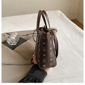Detail of a dark brown mini bucket bag with bear patterns and detachable strap