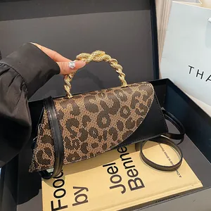 Asymmetric leopard print saddle bag with unique golden snake handle and leather strap