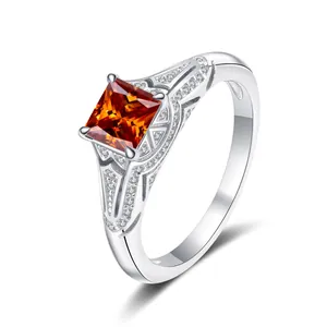 Close-up of square cut orange gemstone set in a vintage silver ring with pave zircon