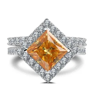 Macro view of princess cut orange gemstone with halo setting on silver ring band