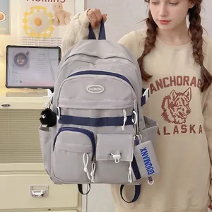 Light gray large capacity school backpack with dark blue straps and plush charm accessory
