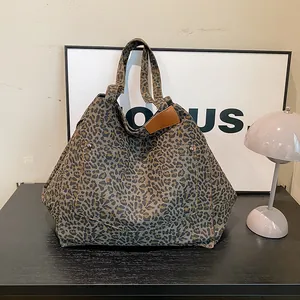 Vintage leopard print tote bag with brown leather trim and metal rivets detail