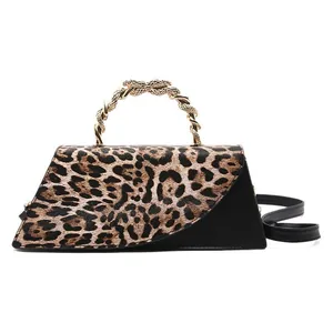 Leopard print crossbody bag with gold metal handle and black patchwork details