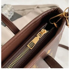 Macro detail of golden metal zipper and brown leather texture with classic logo pattern
