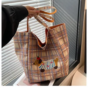 Detail of grid canvas tote bag featuring a cute dachshund embroidery and woven texture