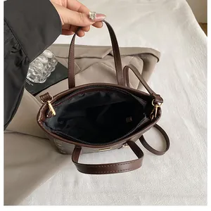 Top-down detail of brown monogram bucket bag interior with golden zipper and inner pocket