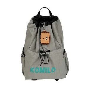 Gray lightweight drawstring backpack with waterproof nylon material and plush cookie charm