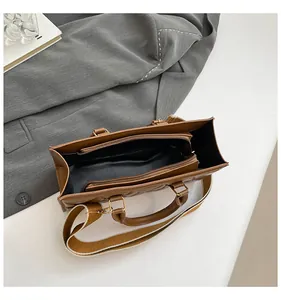 Internal view of brown quilted tote bag showing multi-layer storage and wide strap