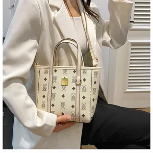 Close-up of cream bucket bag with cartoon bear print and gold metal hardware detail