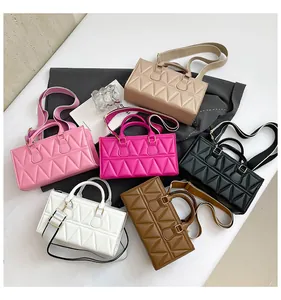 Flat lay of rectangular quilted handbags in six colors with wide fabric straps