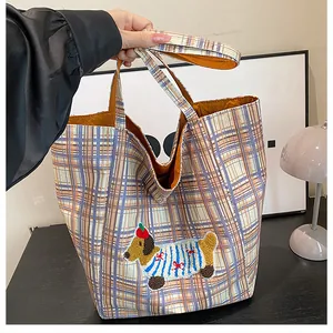Detail of checkered canvas tote bag featuring a cute embroidered dachshund dog patch