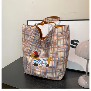 Detail of cute dachshund embroidery and colorful plaid pattern on a canvas tote bag