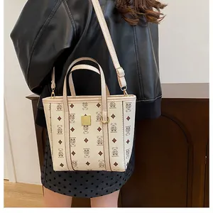 Close-up of beige bucket bag with cartoon bear prints and adjustable shoulder strap