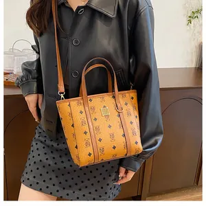Detail of caramel brown tote bag featuring bear prints and pebbled leather texture