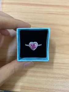 Detailed macro shot of a pink heart-shaped moissanite ring with halo diamonds in a gift box