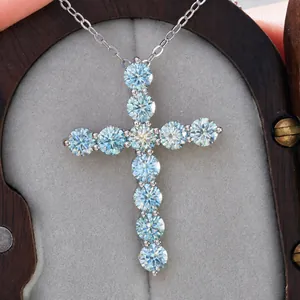 Λήψη macro με μπλε πέτρες Moissanite σε ασημένιο σταυρό με λεπτή αλυσίδα λαιμού
