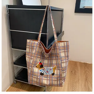 Close-up of a checkered tote bag featuring a cute dog embroidery patch in a cozy room