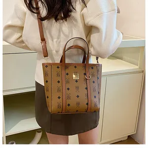 Detail of vintage brown bucket bag with monogram bear print and gold logo hardware