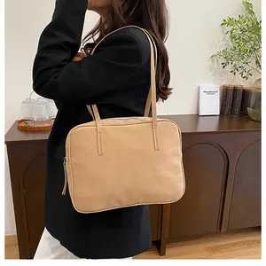 Detail view of khaki suede tote bag with slim shoulder straps worn by model