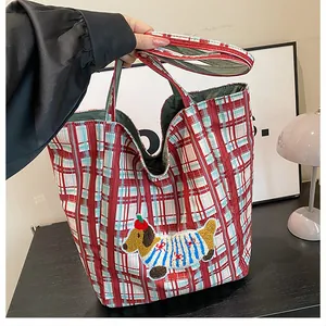 Detail of red checkered canvas tote bag with cute cartoon dachshund embroidery