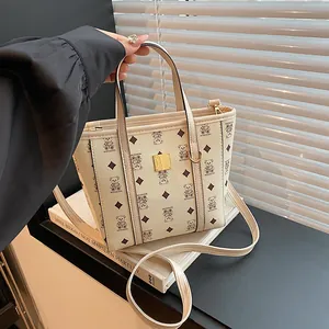 Chic cream bucket bag with bear patterns, featuring dual handles and a long shoulder strap