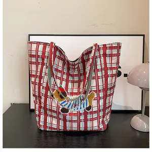 Close-up of red and white checkered canvas tote bag with 3D cartoon puppy embroidery