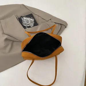 Vintage ginger yellow suede shoulder bag with zipper closure and black fabric lining