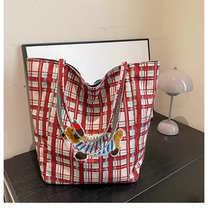 Macro detail of red plaid canvas tote bag featuring a cute cartoon dog embroidery