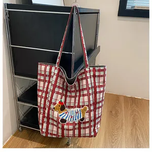 Close-up of red plaid canvas tote bag featuring a cute dachshund embroidery patch