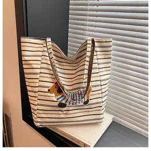 Detail of checkered tote bag featuring a cute dachshund embroidery on striped canvas