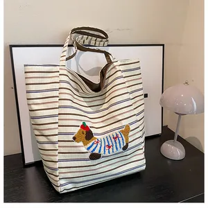 Detailed view of striped canvas tote bag featuring 3D cartoon dachshund plush embroidery