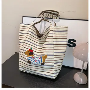 Detailed embroidery of a cute dachshund on a striped canvas tote bag surface
