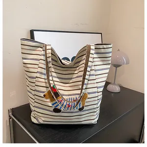Detail of cute embroidered cartoon puppy on a large capacity striped canvas tote bag