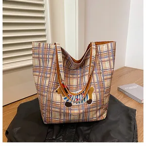 Detail of checkered tote bag with 3D puppy embroidery and brown leather handles