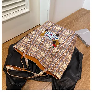Detail of cute plaid tote bag featuring a 3D cartoon dog embroidery on checkered canvas