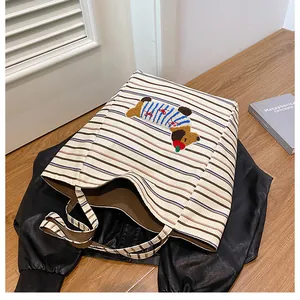Detail of canvas tote bag showing striped pattern and cute puppy embroidery