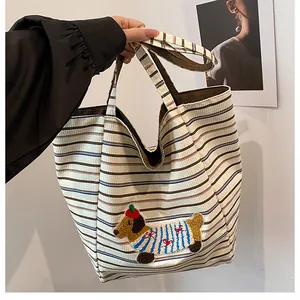 Detail of embroidered dachshund on a striped canvas tote bag with dual shoulder straps